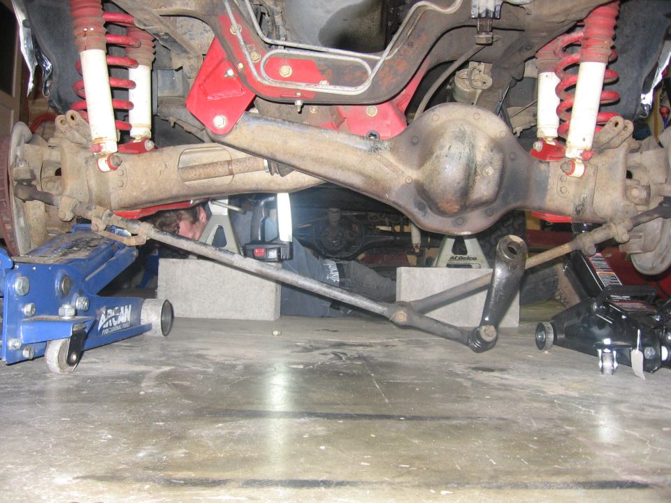 Front axle and red-coil suspension installed under a vehicle on jacks