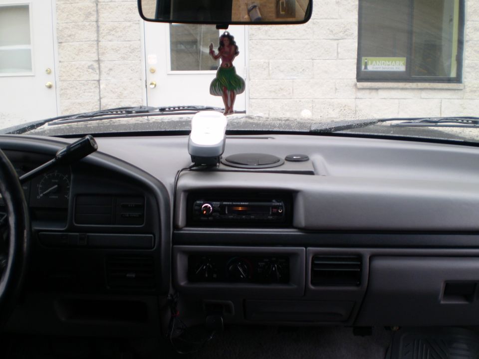 Interior of a 1996 Ford Bronco dashboard with a hula dancer ornament.
