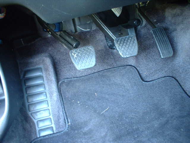 Interior footwell with three manual-transmission pedals and gray carpet