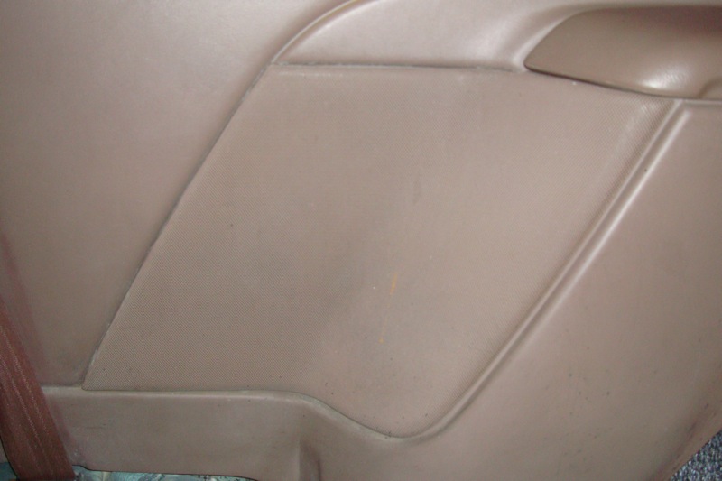 Close-up of a tan vinyl interior door or quarter trim panel