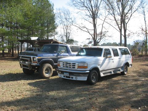 1978 Ford Bronco - Photo of a vintage Ford Bronco and a white Ford crew-cab parked side by side, not a technical document.