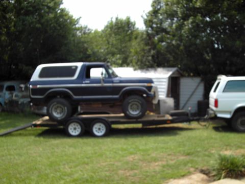 1978 Ford Bronco - A blue and white Ford Bronco is loaded onto a trailer, with another vehicle visible behind it.