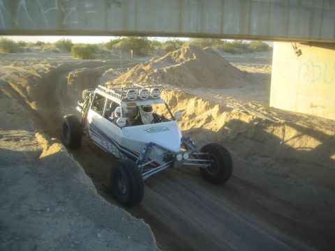1990 Ford Bronco - Photograph of an off-road buggy in a sandy wash, not a technical document.