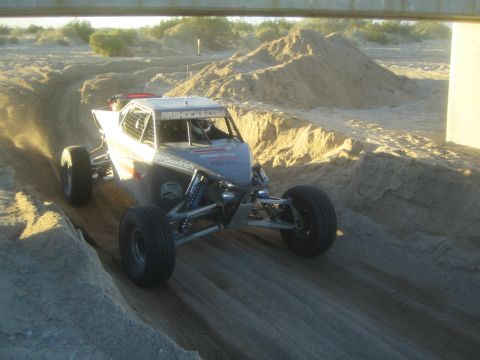 1990 Ford Bronco - Photograph of an off-road race buggy in a sandy wash, not a technical document.