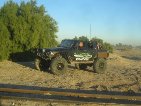 1990 Ford Bronco - Photograph of a lifted off-road truck on a desert trail, not a technical document.