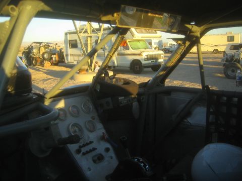 1990 Ford Bronco - Photograph from inside an off-road race vehicle showing the dash and roll cage, not a technical document.