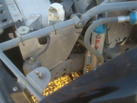 1990 Ford Bronco - Photograph of an off-road vehicle engine bay with shock and plumbing, not a technical document.