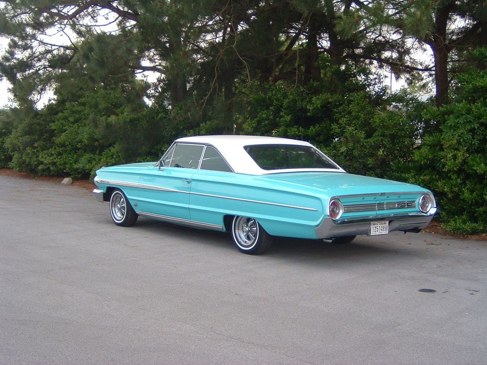 Turquoise Ford Galaxie hardtop with white roof and whitewall tires, rear three-quarter view