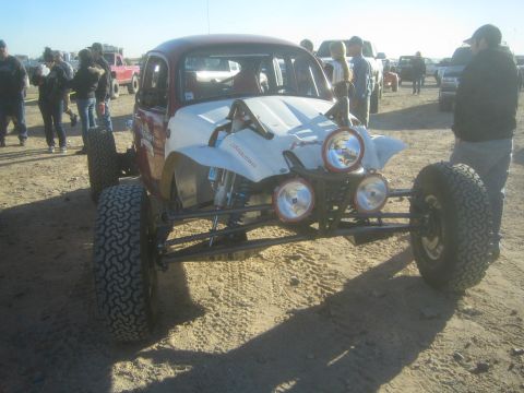 1990 Ford Bronco - Photograph of a white Baja Bug race car showing exposed front suspension in a desert pit, not a technical document.