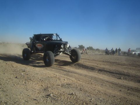 1990 Ford Bronco - Photo of an off-road race buggy racing through the desert, not a technical document.