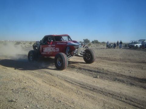 1990 Ford Bronco - Photo of a tube-chassis off-road race buggy on a desert course, not a technical document.