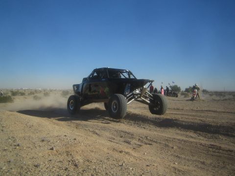 1990 Ford Bronco - Photo of an off-road race buggy racing in the desert, not a technical document.