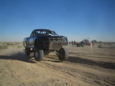 1990 Ford Bronco - Photo of an off-road race truck jumping on a desert course, not a technical document.