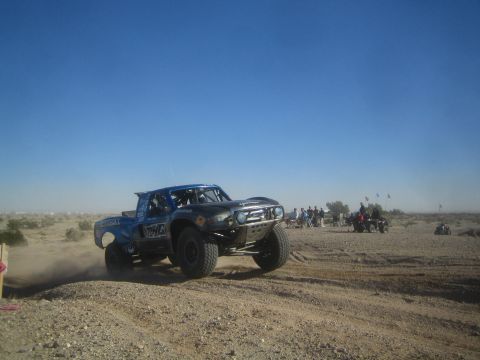 1990 Ford Bronco - Photo of an off-road race truck on a dusty desert course, not a technical document.