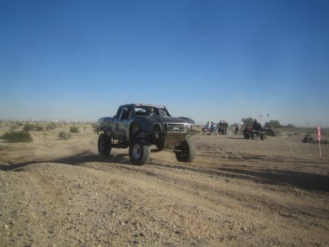 1990 Ford Bronco - Photo of an off-road race truck on a desert course, not a technical document.