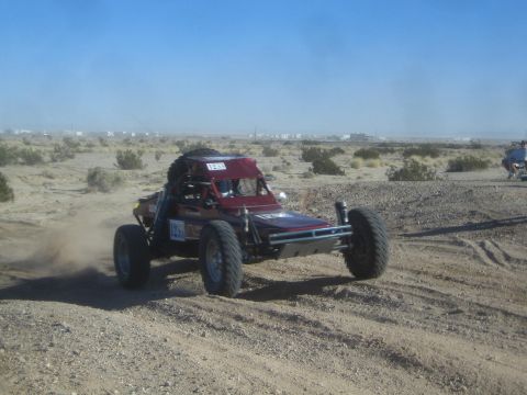 1990 Ford Bronco - Photo of a single-seat off-road race buggy in the desert, not a technical document.