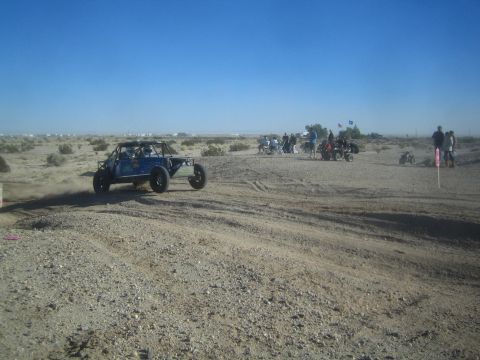 1990 Ford Bronco - Photograph of a blue off-road race buggy on a dusty desert track, not a technical document.