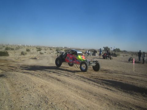 1990 Ford Bronco - Photograph of a colorful off-road race buggy on a desert course, not a technical document.
