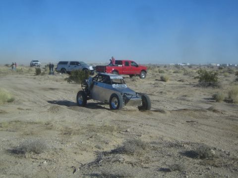1990 Ford Bronco - Photograph of a gray off-road race buggy in the desert, not a technical document.