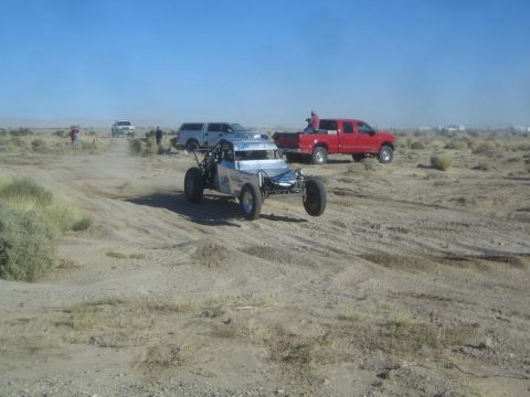 1990 Ford Bronco - Photograph of a silver off-road race buggy in the desert, not a technical document.