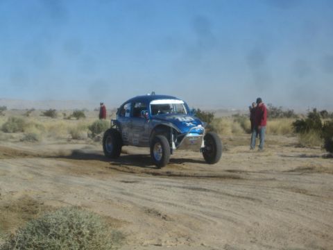 1990 Ford Bronco - Photograph of a blue Baja Bug race car in the desert, not a technical document.