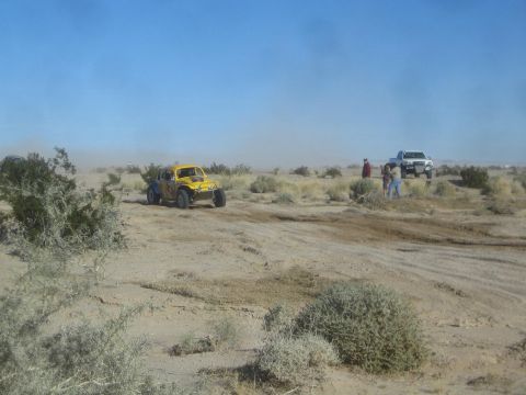 1990 Ford Bronco - Photograph of a yellow Baja Bug race car in the desert, not a technical document.