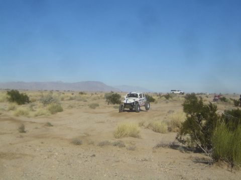 1990 Ford Bronco - Photograph of a white off-road race buggy in the desert, not a technical document.