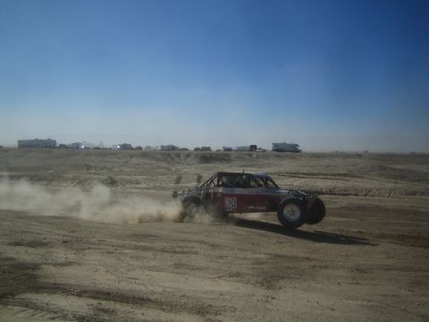 1990 Ford Bronco - Action photo of a numbered off-road buggy at speed on a desert course, not a technical document.