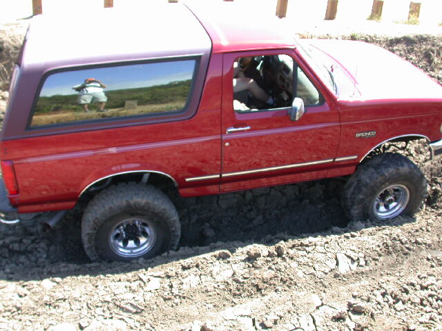 Red 1996 Ford Bronco stuck in dirt, side view
