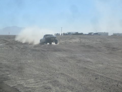 1990 Ford Bronco - Action photo of an off-road truck at speed kicking up dust, not a technical document.