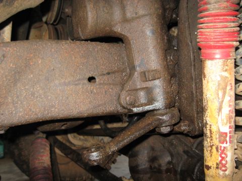1978 Ford Bronco - Close-up of heavily corroded vehicle suspension components and a shock absorber.
