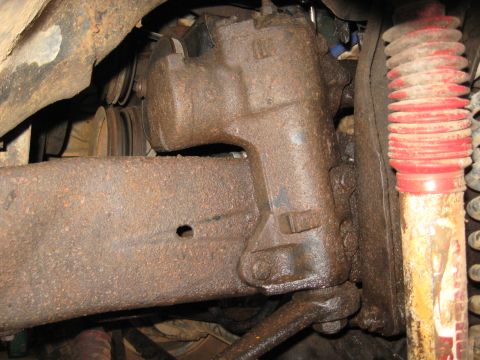 1978 Ford Bronco - Underside view of heavily rusted steering and suspension parts, likely from an older vehicle.
