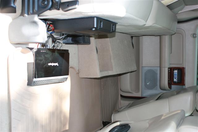 Interior view of aftermarket audio amplifiers mounted above seats