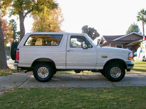 1995 Ford Bronco - This 1995 Ford Bronco is shown from the side, parked in front of a house.