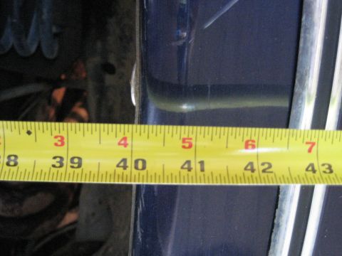 1978 Ford Bronco - A yellow measuring tape is placed against a dark blue vehicle panel, showing measurements in inches.