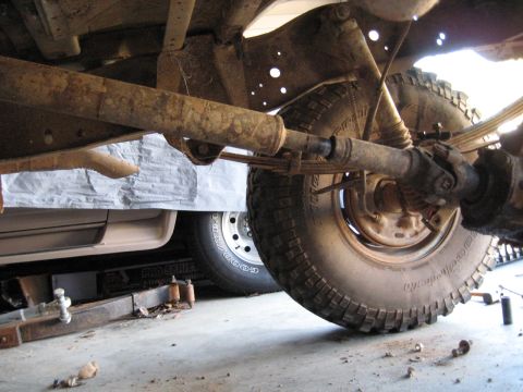 1978 Ford Bronco - The underside of a vehicle is shown, with focus on the suspension and a large tire.