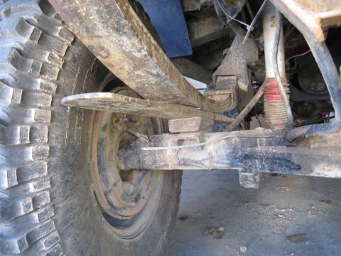 1978 Ford Bronco - This image shows the rear suspension and tire of a vehicle, focusing on the leaf springs and shock absorber.