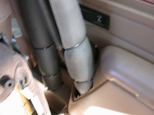 Interior close-up of padded gray roll bar tubing beside tan wheel-well trim