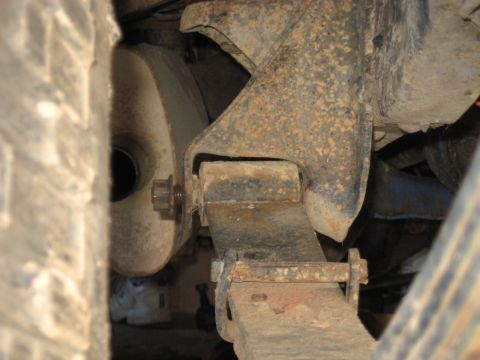 1978 Ford Bronco - Close-up of a rusty leaf spring and exhaust pipe, likely from an older vehicle's suspension.