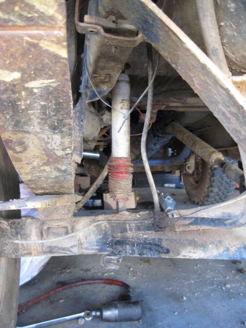 1978 Ford Bronco - Close-up view of the undercarriage of a vehicle, showing suspension components and a drive shaft.