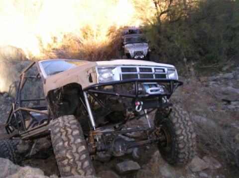 1986 Toyota Hilux - Modified pickup truck navigating rocky terrain with another vehicle following.