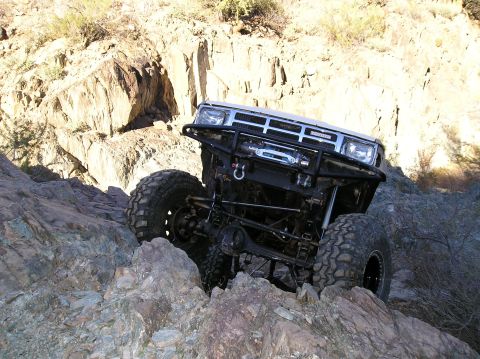 1986 Toyota Hilux - This heavily modified Toyota truck navigates a challenging rocky trail, its off-road capabilities.