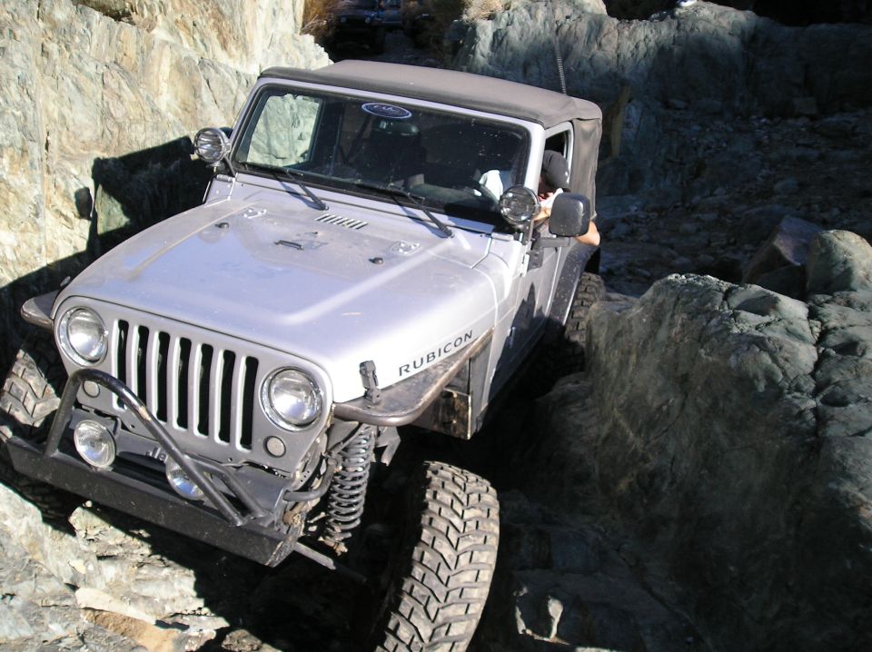 Silver Jeep Wrangler Rubicon on rocky terrain