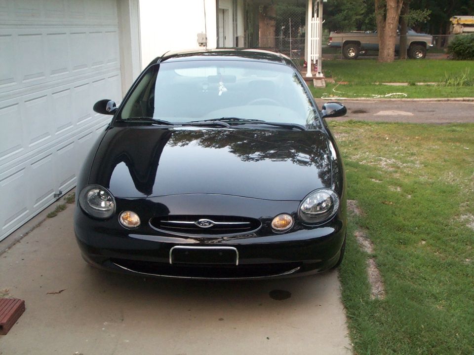 Black sedan parked in front of a garage door