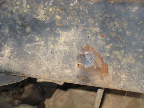 1978 Ford Bronco - Close-up view of a heavily rusted metal frame section, showing wear and tear.