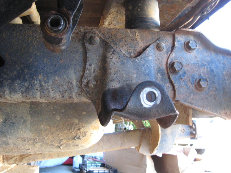 Close-up of a rusty suspension lift bracket on a vehicle frame