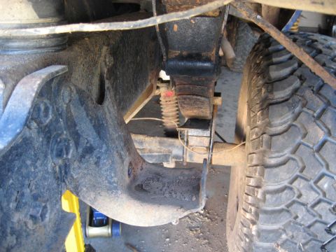 1978 Ford Bronco - Detail of a vehicle's suspension system, focusing on the leaf spring and mounting bracket.