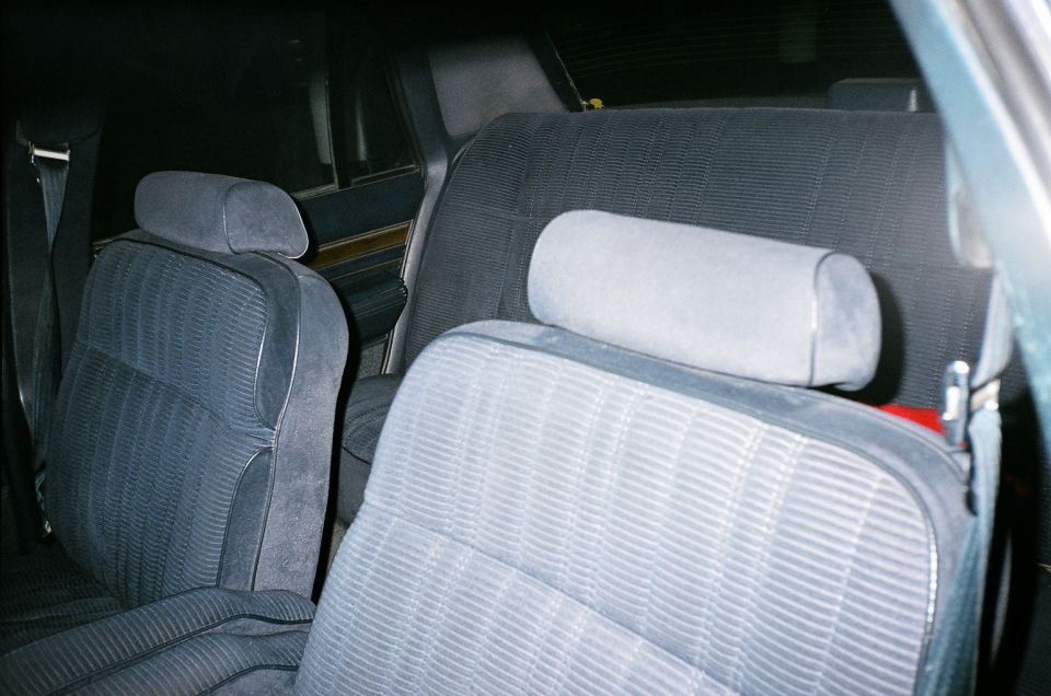 Blue cloth front bucket seats inside an older sedan