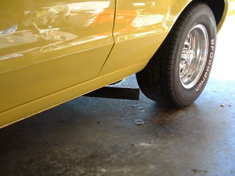 1978 Ford Ranchero - Close-up view of the side panel and rear wheel of a yellow vehicle, a BFGoodrich tire.