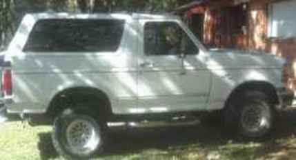 1995 Ford Bronco - This 1995 Ford Bronco is seen from the side, parked outdoors near a building.